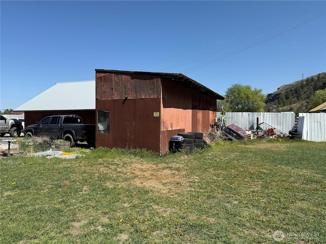 view of pole building featuring fence and a yard