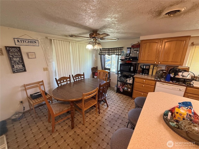 dining room featuring a ceiling fan, a textured ceiling, and visible vents