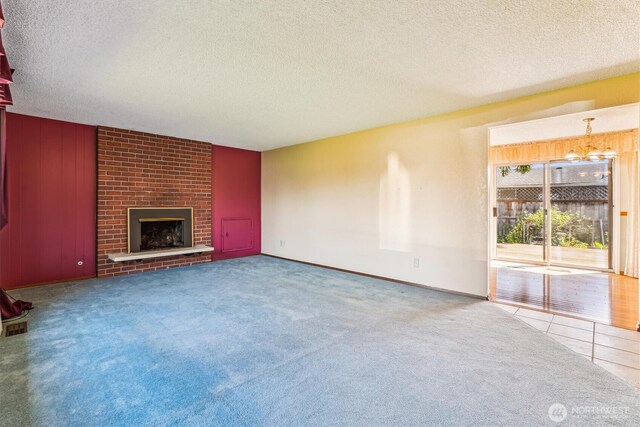 1015 14th St NW, Puyallup, WA 98371 - unfurnished living room with carpet floors, a textured ceiling, an inviting chandelier, and a brick fireplace