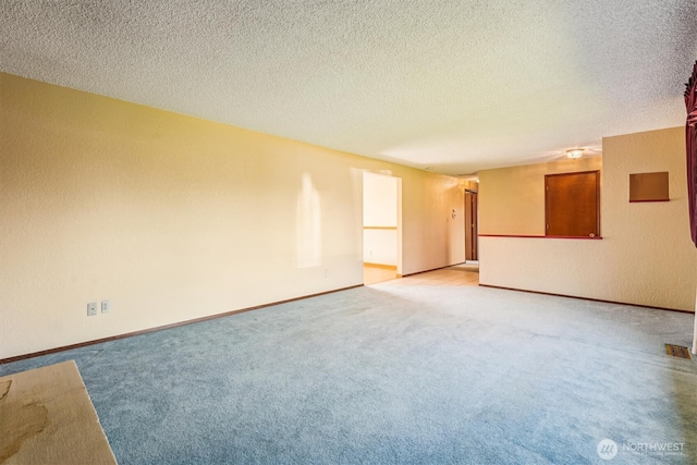 1015 14th St NW, Puyallup, WA 98371 - empty room featuring baseboards, a textured ceiling, and light carpet
