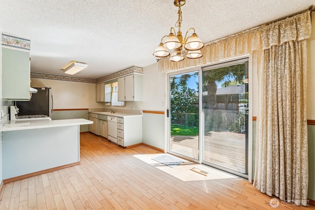 1015 14th St NW, Puyallup, WA 98371 - kitchen featuring light countertops, white dishwasher, a textured ceiling, and a notable chandelier