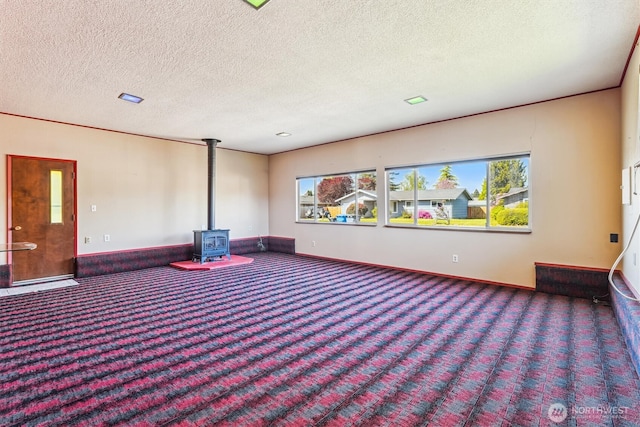 1015 14th St NW, Puyallup, WA 98371 - carpeted cinema room with a textured ceiling, plenty of natural light, baseboards, and a wood stove