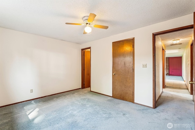1015 14th St NW, Puyallup, WA 98371 - unfurnished bedroom featuring baseboards, a ceiling fan, a textured ceiling, and light colored carpet