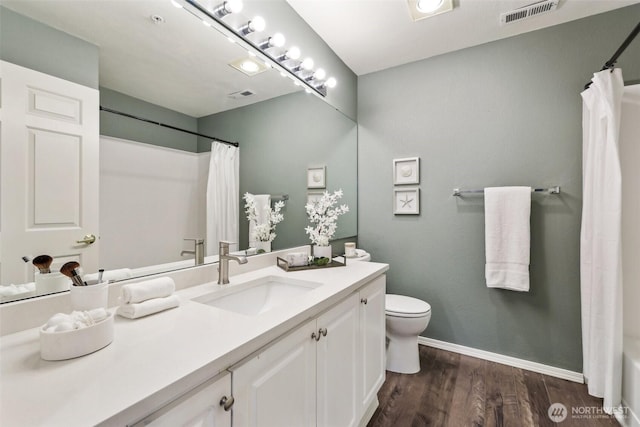 full bath with vanity, toilet, wood finished floors, and visible vents