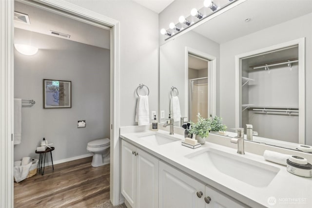 bathroom with visible vents, a sink, wood finished floors, and toilet