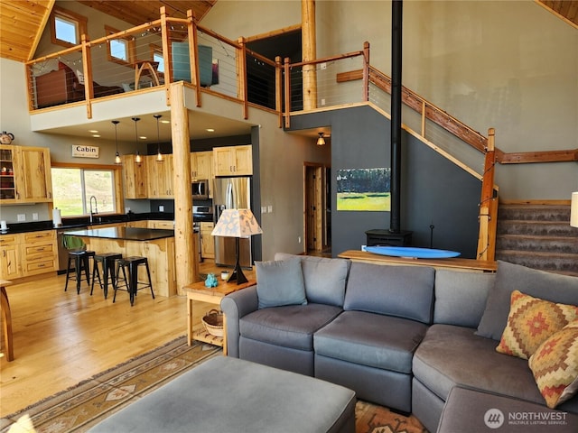 living room featuring stairway, high vaulted ceiling, wood ceiling, and light wood-type flooring