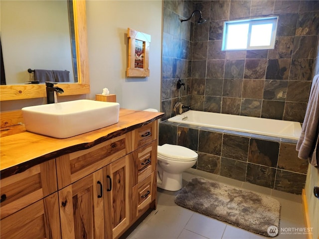 bathroom with toilet, tiled shower / bath, tile patterned flooring, and vanity