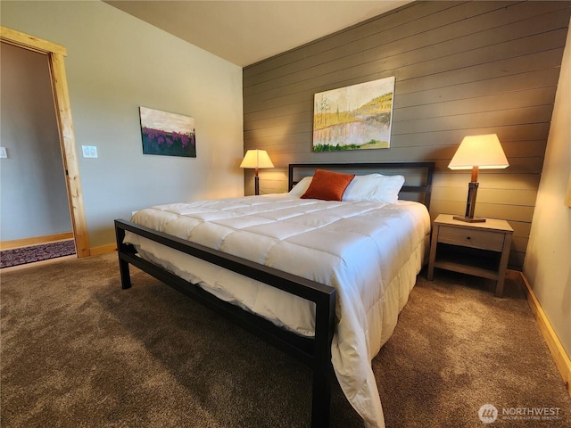 bedroom with carpet floors, wooden walls, and baseboards