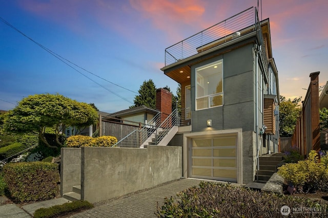 contemporary home featuring stairway, an attached garage, and stucco siding