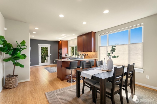 dining space with baseboards, recessed lighting, and light wood-style flooring