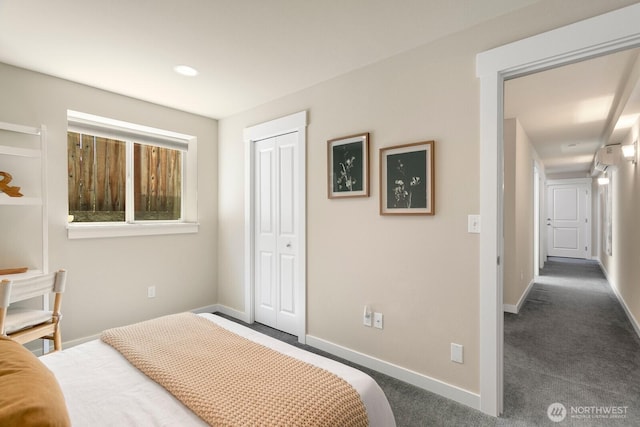 carpeted bedroom featuring baseboards and a closet