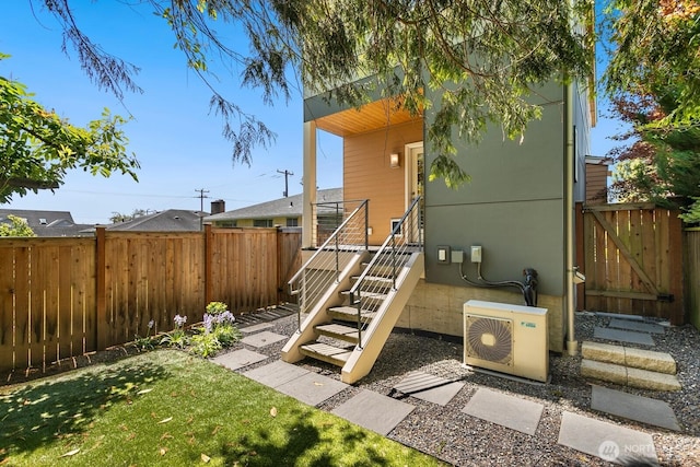 exterior space with a yard, a gate, ac unit, and a fenced backyard