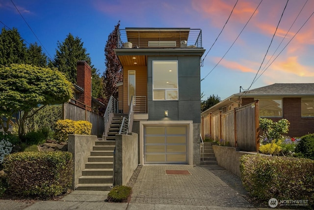 view of front of house featuring stairs, decorative driveway, and an attached garage