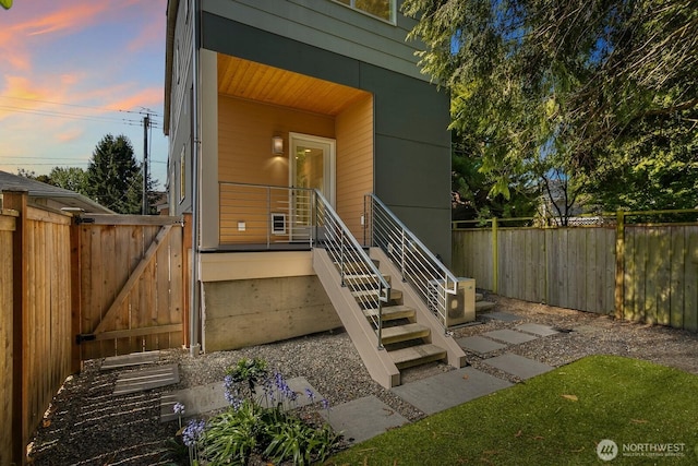 exterior entry at dusk with fence and a gate