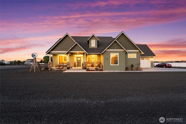 view of front facade with a garage, concrete driveway, and a porch