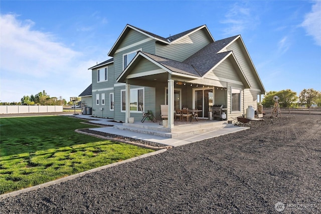rear view of property featuring fence, a shingled roof, cooling unit, a patio, and a yard
