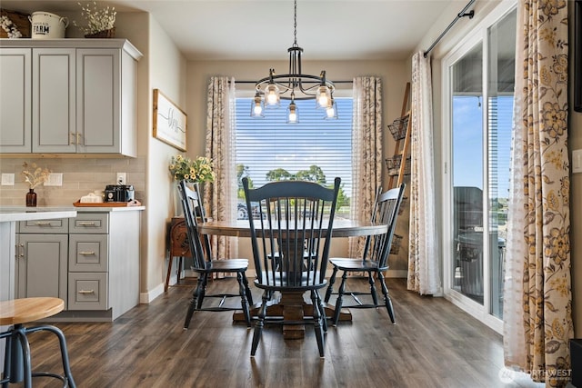 dining space featuring a chandelier, dark wood-style floors, and a healthy amount of sunlight