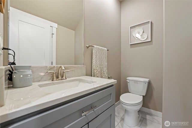 bathroom with vanity, marble finish floor, baseboards, and toilet