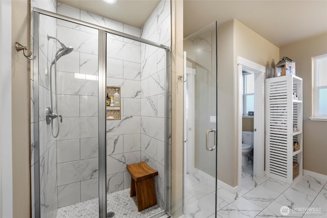 full bathroom with baseboards, a shower stall, toilet, and marble finish floor