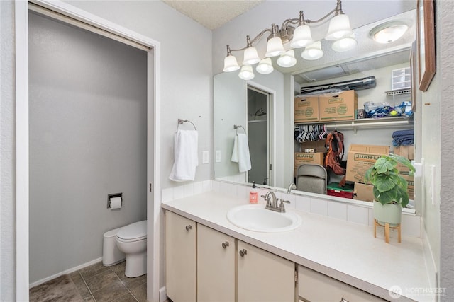 bathroom featuring vanity, toilet, and baseboards