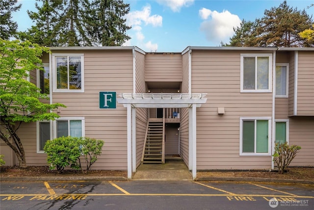 view of building exterior featuring uncovered parking and stairway