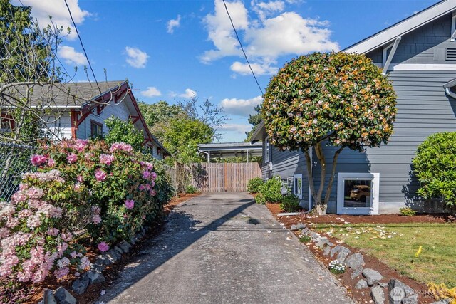 view of property exterior featuring driveway and fence
