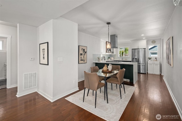 dining area featuring dark wood-style flooring and baseboards