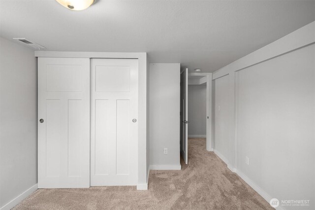 unfurnished bedroom with light colored carpet and baseboards