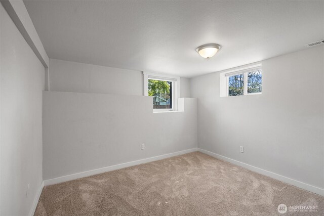 carpeted empty room with baseboards