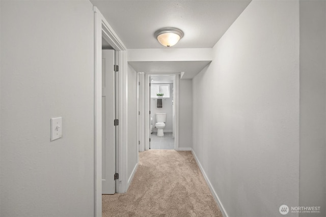 hallway with light carpet and baseboards