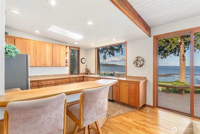 3003 Haxton Way, Bellingham, WA 98226 - kitchen with freestanding refrigerator, a skylight, light wood-style flooring, light countertops, and a water view