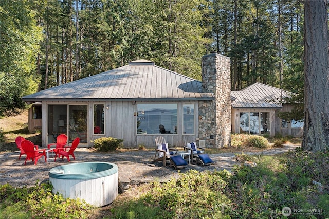 30 Smugglers Rowe, Henry Island, WA 98250 - back of property featuring a chimney, a standing seam roof, metal roof, an outdoor fire pit, and a patio