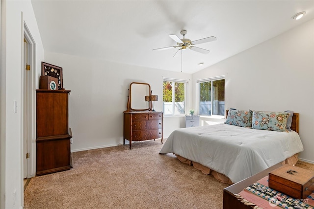 carpeted bedroom with ceiling fan, vaulted ceiling, and baseboards