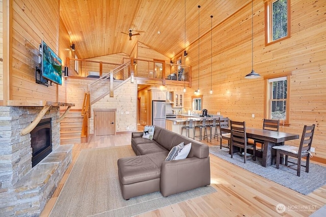 living area with high vaulted ceiling, wood ceiling, wood walls, and light wood-style flooring