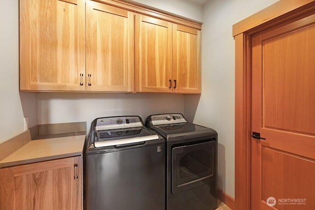 clothes washing area with cabinet space and washing machine and dryer