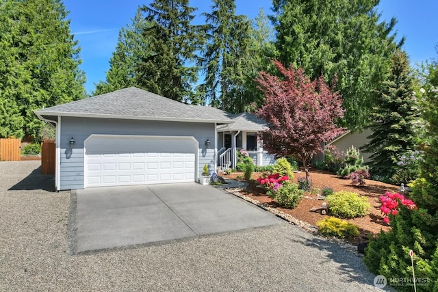 view of front facade with a garage, fence, concrete driveway, and roof with shingles