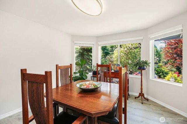 dining room with baseboards and light wood finished floors