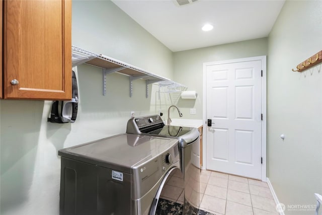 laundry room featuring separate washer and dryer, cabinet space, light tile patterned floors, baseboards, and recessed lighting