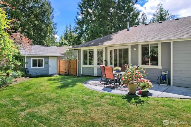 back of house featuring a patio area and a shingled roof