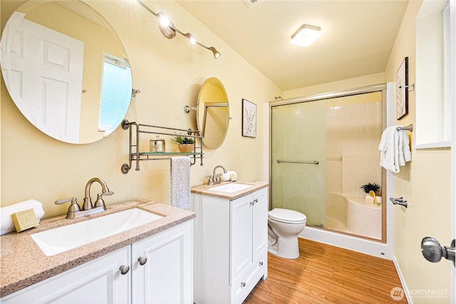 18514 71st St NW, Vaughn, WA 98394 - bathroom with a shower stall, wood finished floors, two vanities, and toilet