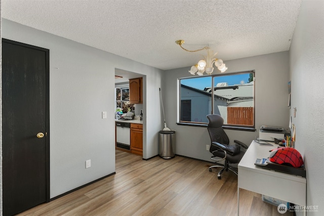 home office with light wood finished floors, a textured ceiling, and a notable chandelier