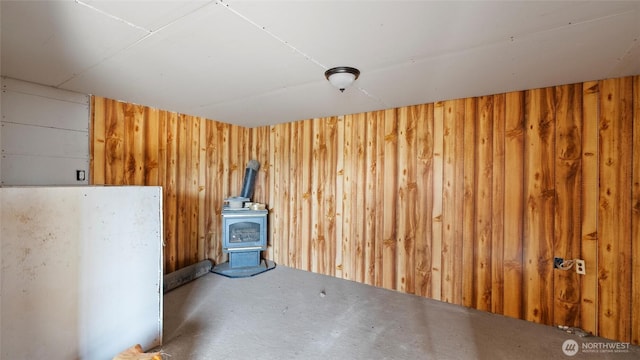 interior space with a wood stove and wooden walls