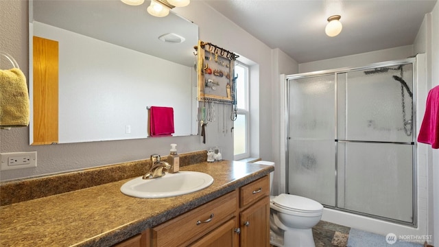 full bathroom featuring vanity, toilet, and a shower stall