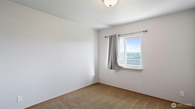 unfurnished room featuring baseboards and carpet