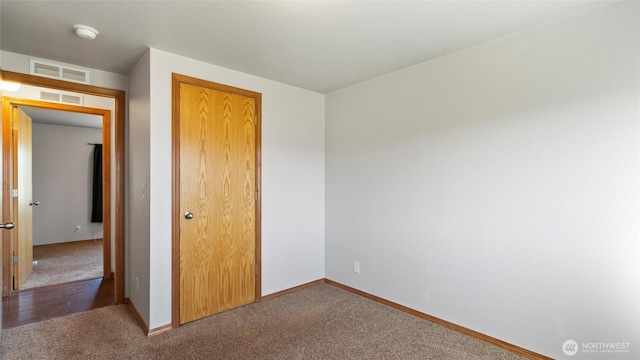 unfurnished bedroom featuring carpet floors, baseboards, and visible vents