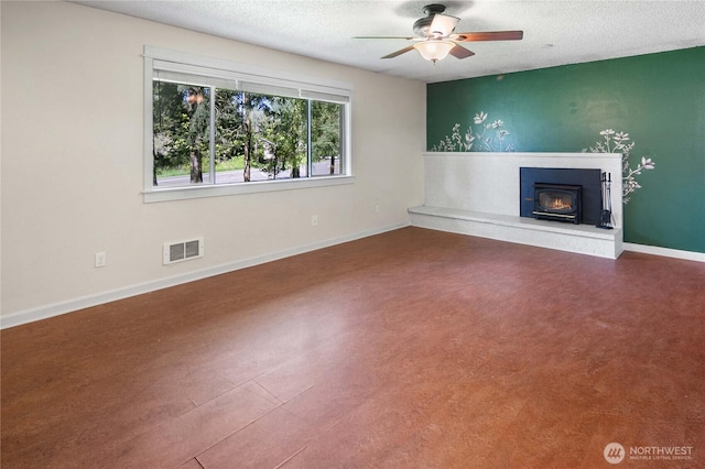 unfurnished living room with visible vents, a textured ceiling, ceiling fan, and baseboards