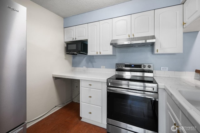 kitchen with tile counters, a textured ceiling, white cabinetry, under cabinet range hood, and stainless steel appliances