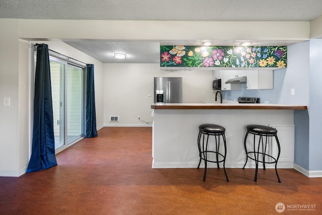 kitchen featuring a kitchen breakfast bar, baseboards, white cabinets, a peninsula, and stainless steel appliances