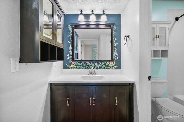 bathroom with vanity, a textured ceiling, and toilet