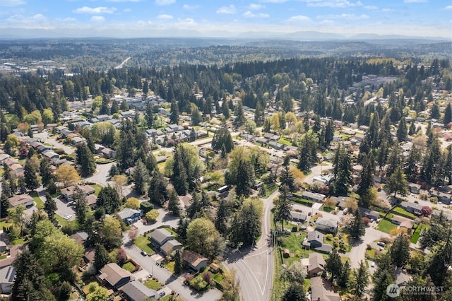 drone / aerial view featuring a forest view and a residential view